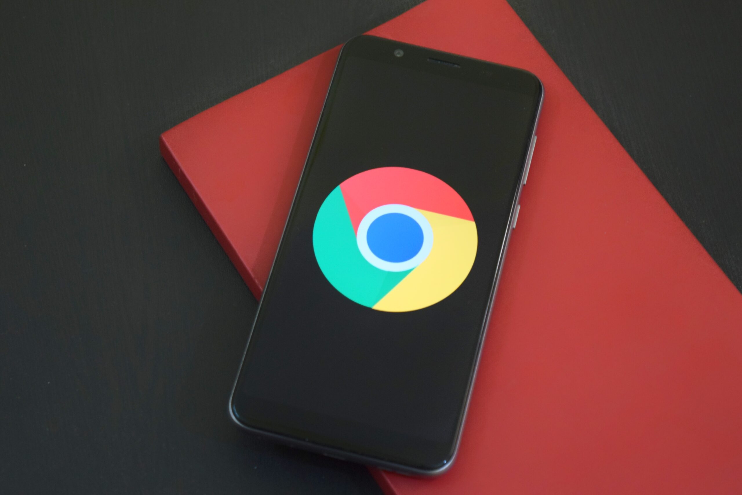 Android-telefoon met Chrome-logo op rood notitieboek