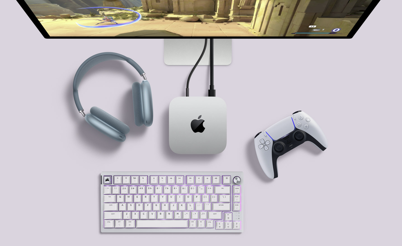 Foto van bureau met Mac mini, toetsenbord, monitor, PlayStation-controllers